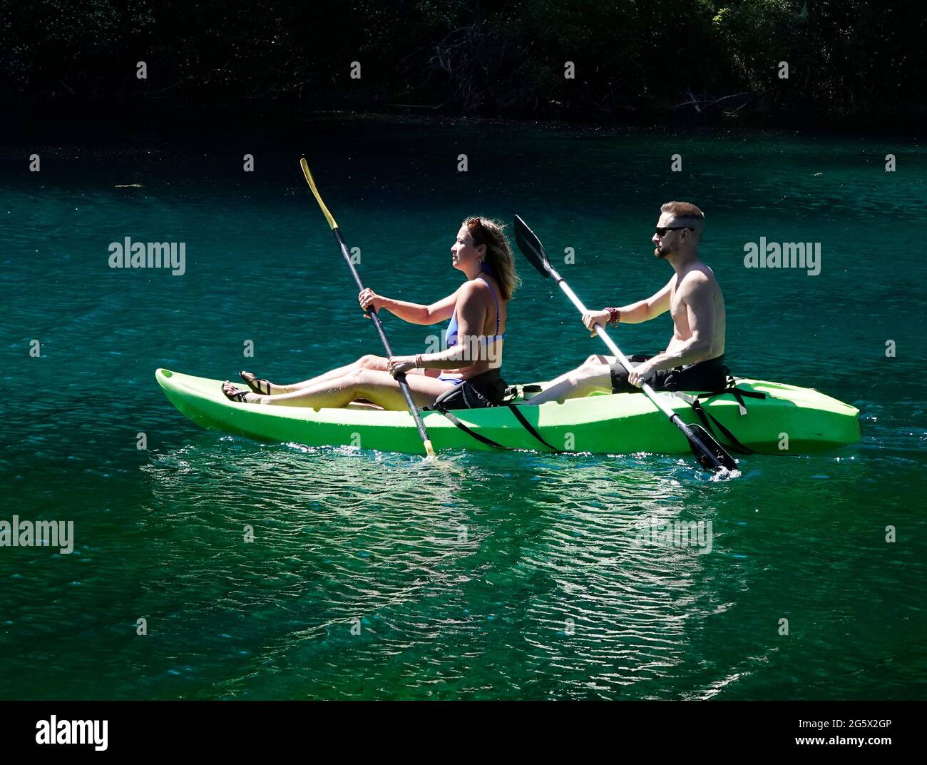 Les jeunes se rafraîchit dans un kayak pour deux personnes sur Clear Lake lors d'une chaude journée d'été dans les Cascades de l'Oregon. Banque D'Images