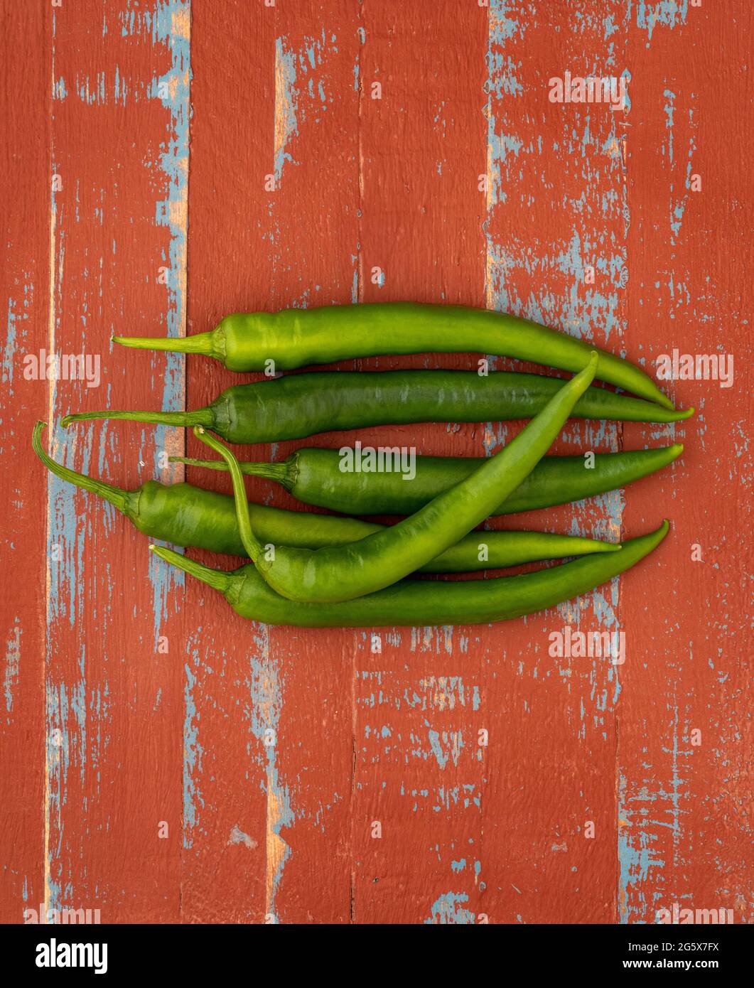 Plan de vue sur les piments verts sur un fond en bois marron et bleu. Banque D'Images