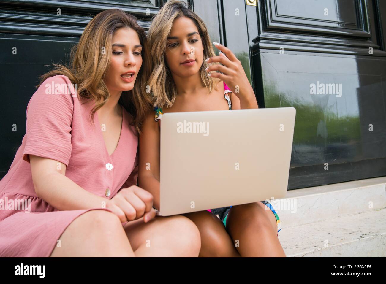 Deux amis utilisant un ordinateur portable à l'extérieur. Banque D'Images