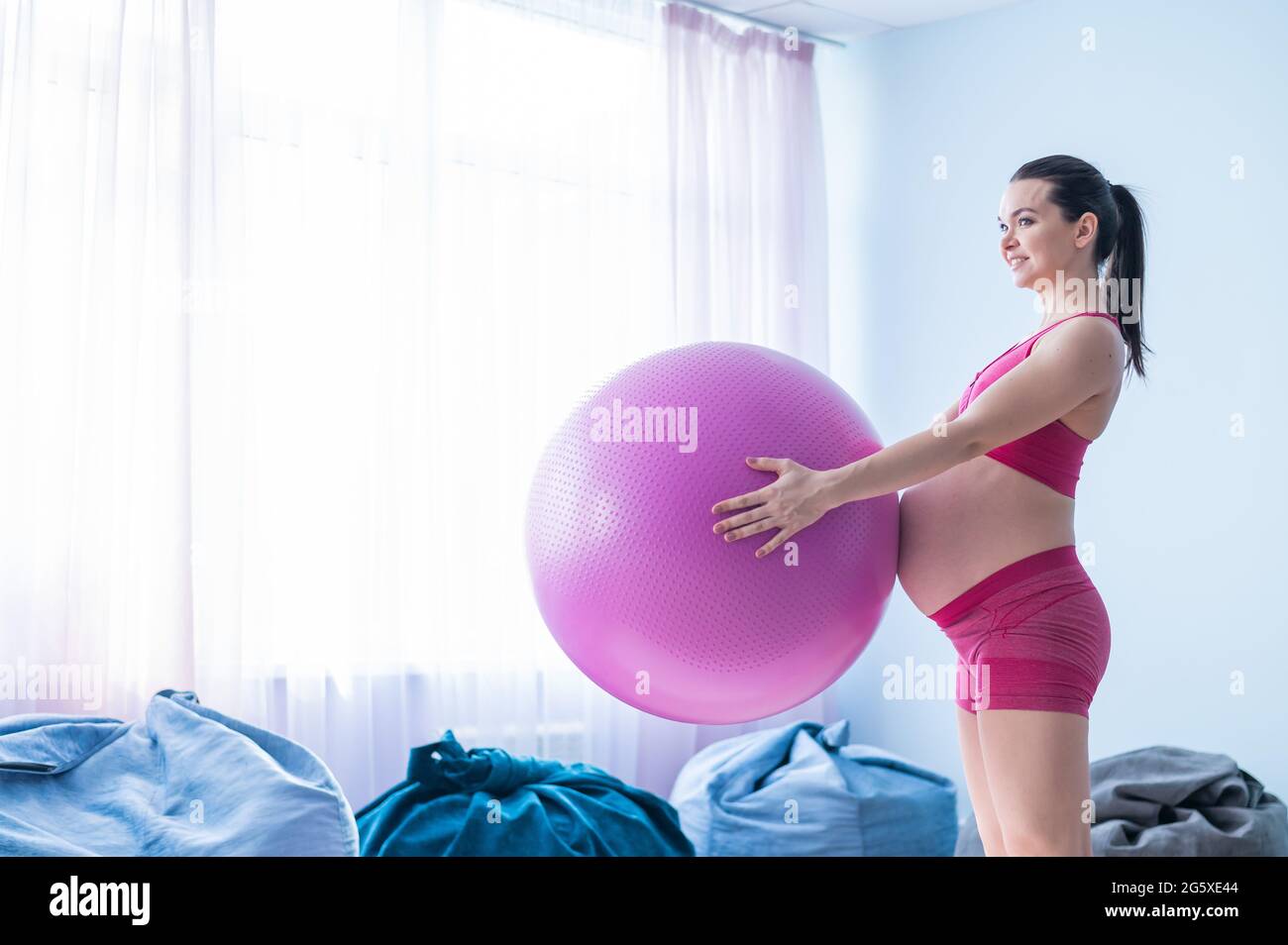 Une femme enceinte en vêtements de sport fait de la gymnastique pour les  femmes enceintes. La fille est engagée dans la forme physique avec une  balle pour les femmes enceintes. Dernier Photo