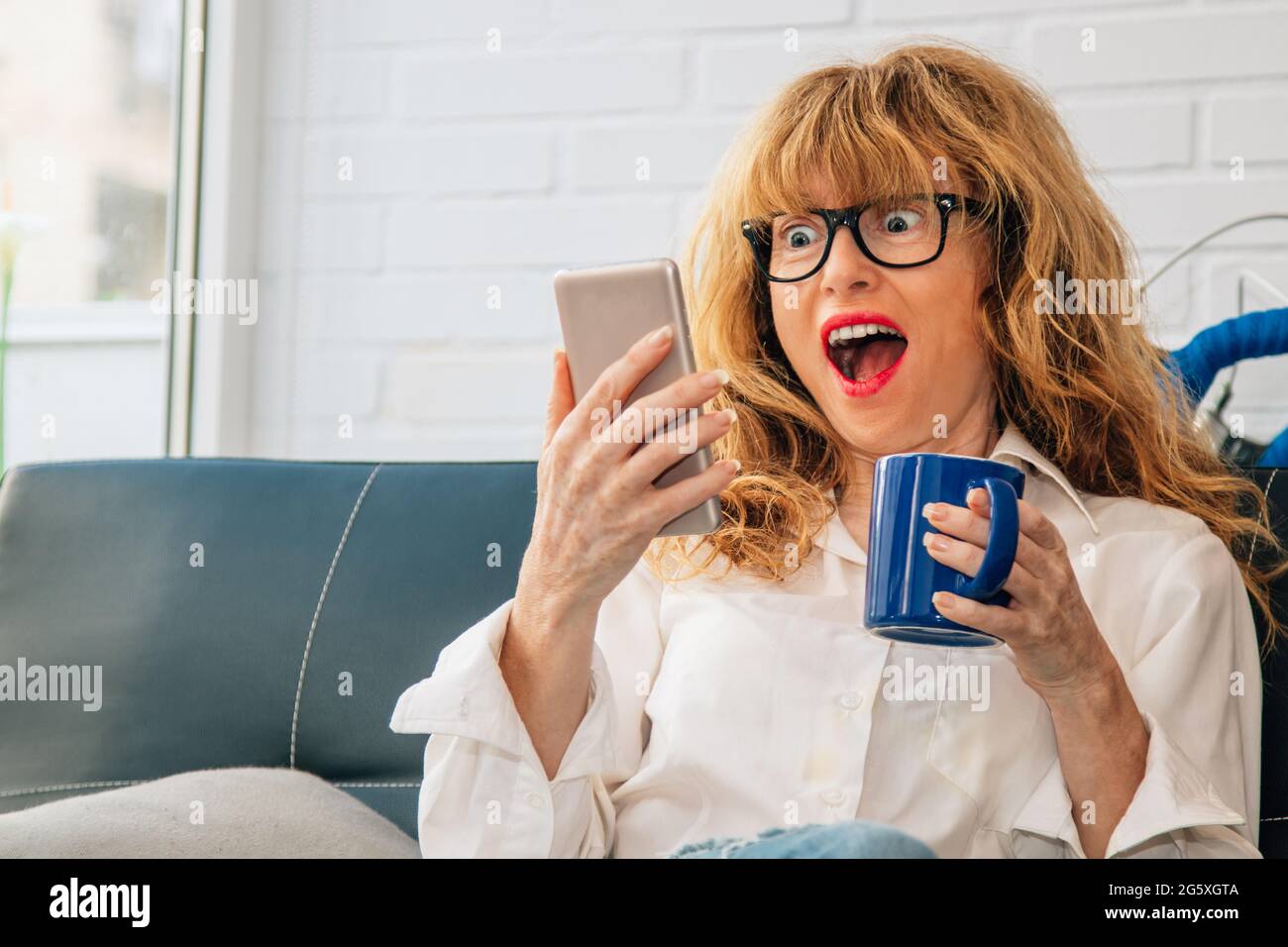 femme avec ordinateur et une tasse de café à la maison Banque D'Images