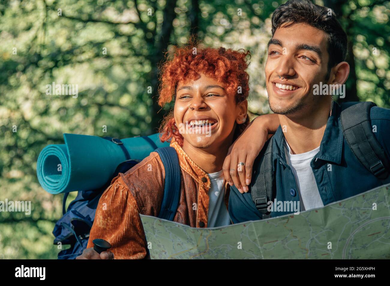 jeune couple multiethnique lors d'un voyage en sac à dos en regardant la carte Banque D'Images