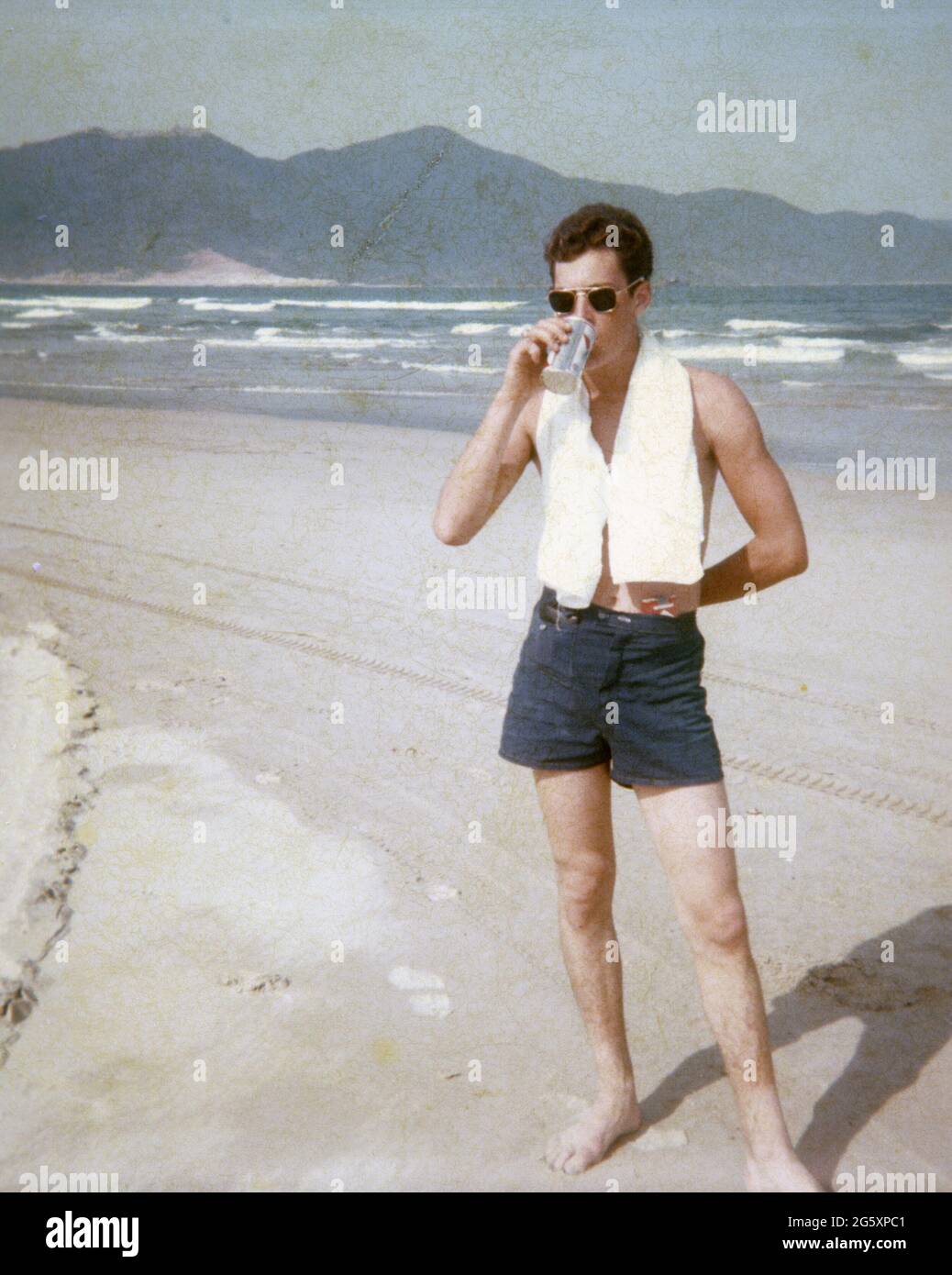 Photo authentique d'un marin sur China Beach pendant la guerre du Vietnam, en buvant une bière. Banque D'Images