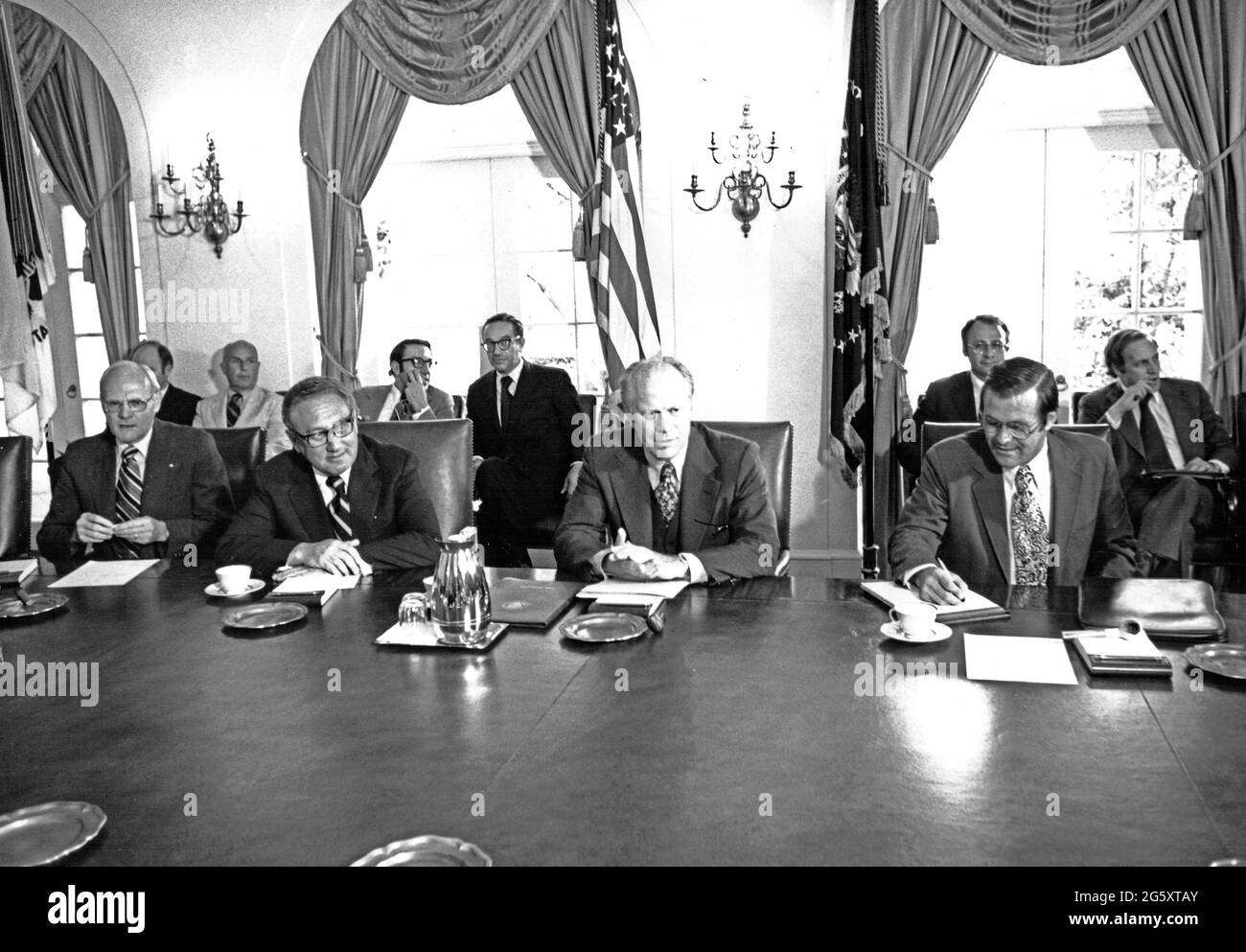 Le président des États-Unis, Gerald R. Ford, présente son cabinet après son retour du Sommet économique international de deux jours sur Dorado Beach, à Porto Rico, dans la salle du Cabinet de la Maison Blanche à Washington, DC, le 29 juin 1976. Assis à la table, de gauche à droite : le secrétaire AMÉRICAIN à l'intérieur Thomas S. Kleppe, le secrétaire d'État américain Henry A. Kissinger, le président Ford et le secrétaire américain à la Défense Donald H. Rumsfeld. Parmi ceux qui sont assis à l'arrière-plan, de gauche à droite, on compte: L. William Seidman, directeur exécutif du Conseil de politique économique et adjoint aux affaires économiques; Alan Greenspan, Banque D'Images