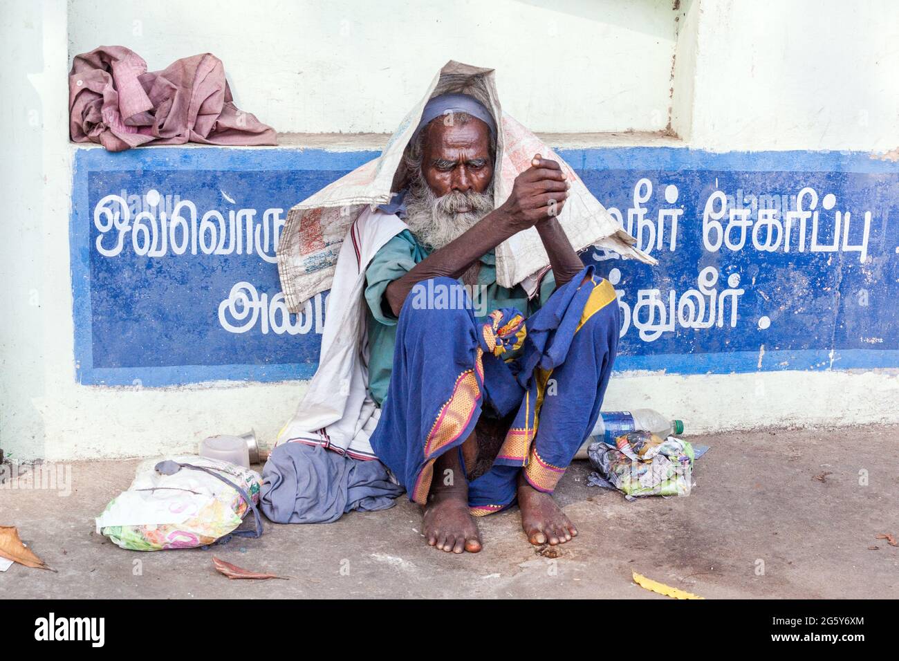 Homme indien âgé gris bushy barbu sans-abri dormeur agitée assis endormi sur la chaussée, Trichy, Tamil Nadu, Inde Banque D'Images