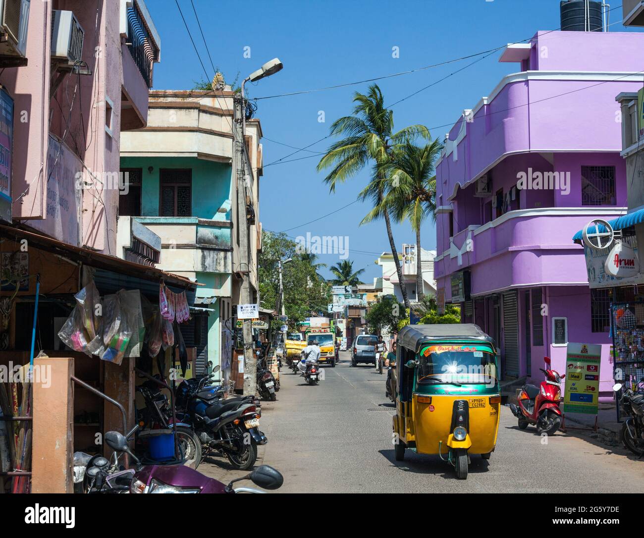 Un pousse-pousse automobile indien passe devant un bâtiment de style art déco aux couleurs pastel à Puducherry (Pondicherry), tamil Nadu, en Inde Banque D'Images