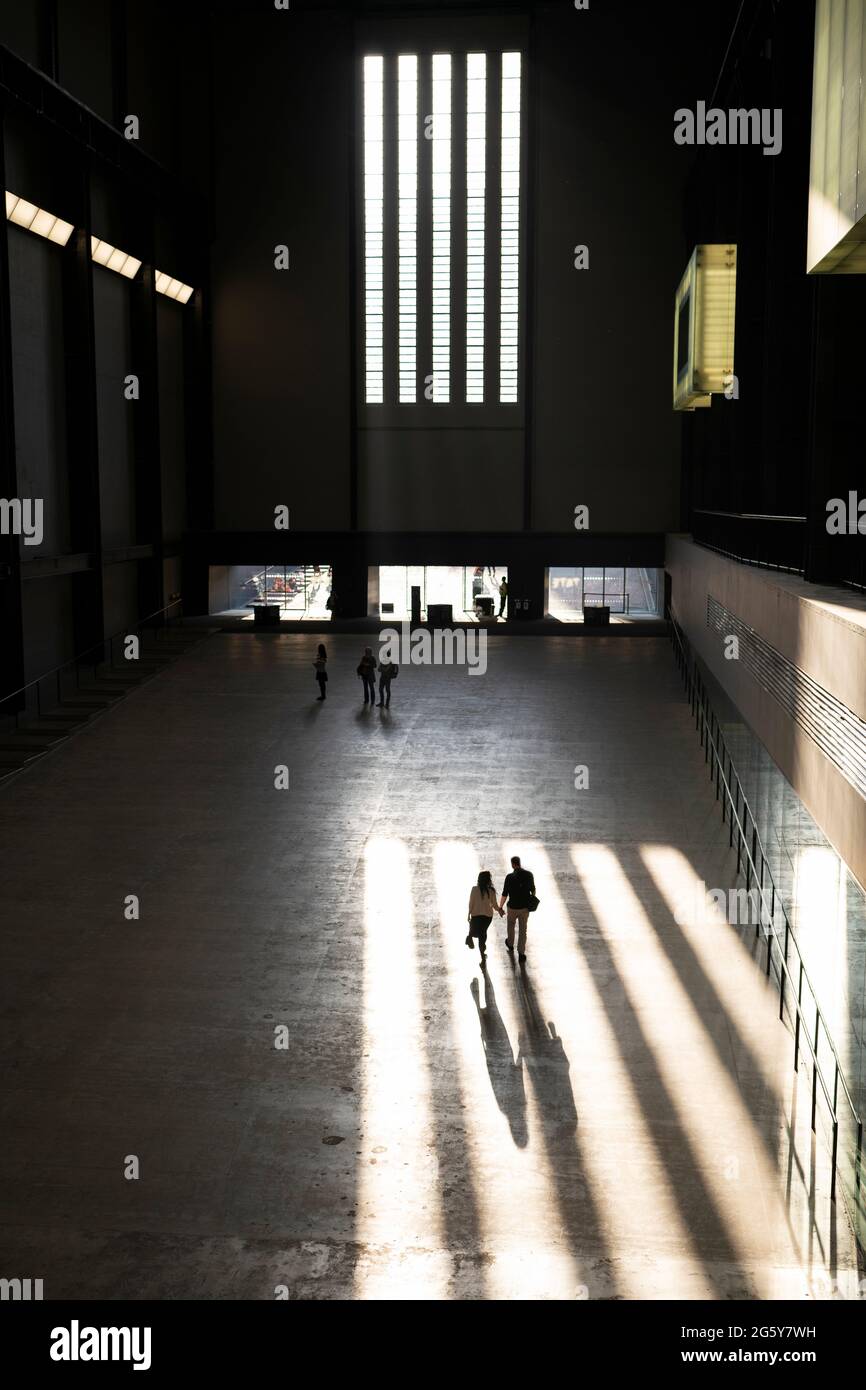 Un couple qui marche à travers un puits de lumière dans le Tate Modern de Londres, Royaume-Uni Banque D'Images