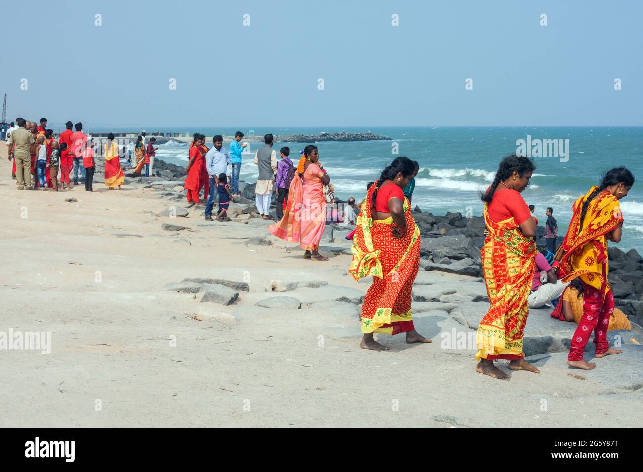 Des femelles indiennes portant des saris colorés rouges et jaunes en profitant du temps au bord de la mer, Puducherry (Pondichéry), Tamil Nadu, Inde Banque D'Images
