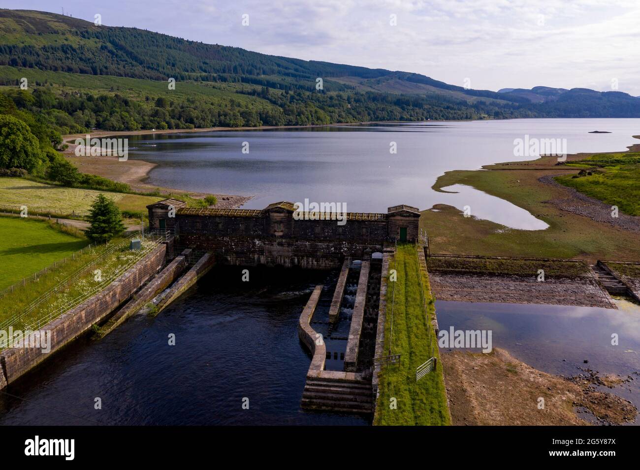 Loch Venachar, Loch. Lomonnd et Trossachs National Park, Écosse, Royaume-Uni. 30 juin 2021. PHOTO : une vue en grand angle de la plage de galets et de pierre sur le Loch Venachar, qui est normalement sous quelques pieds d'eau, est exposée en raison de la diminution de l'alimentation en eau utilisée. Il ne devrait pas y avoir de plage sur cette partie du loch, mais les gens peuvent être vus en utilisant cette plage de make Shift pour prendre le soleil en soirée. Crédit : Colin Fisher/Alay Live News Banque D'Images