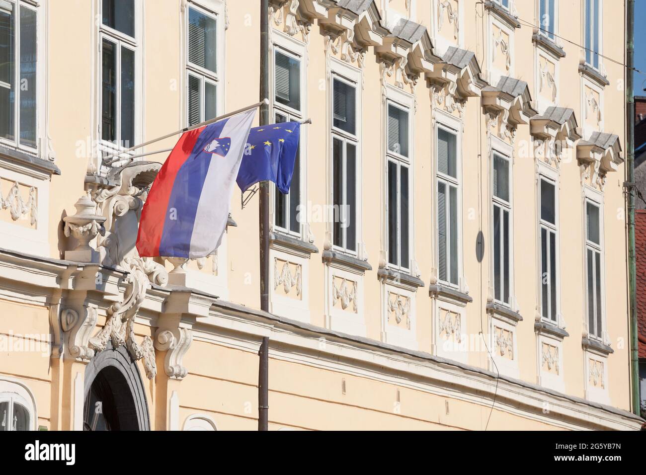 Photo du drapeau de la Slovénie et du drapeau de l'UE ensemble devant un bâtiment de Ljubljana. La Slovénie est l'un des principaux membres de l'Europe Banque D'Images