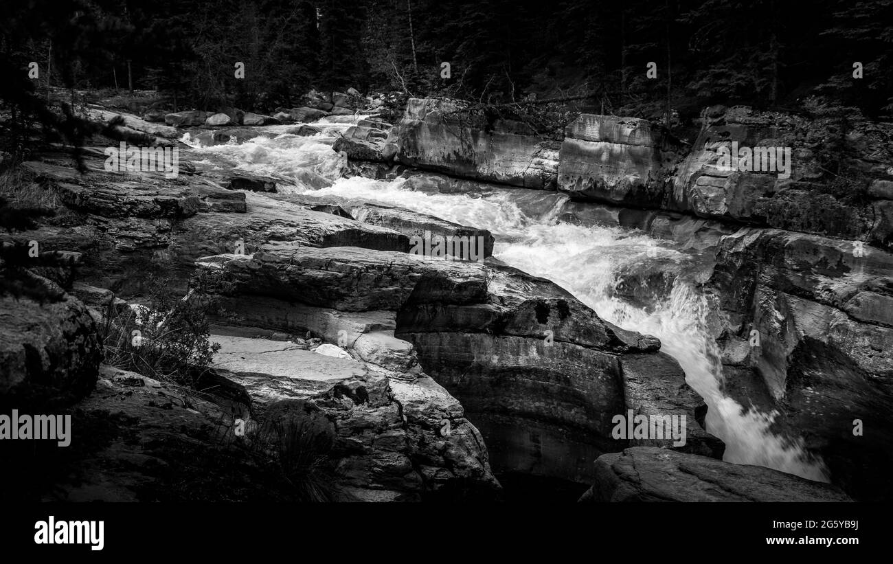 Noir et blanc photo de la rivière Maligne qui entre dans le canyon Maligne en amont du premier pont dans le parc national Jasper des montagnes Rocheuses, en Alberta Banque D'Images