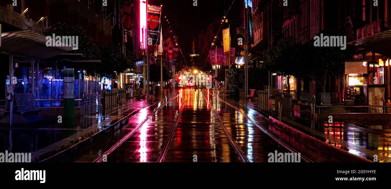 Melbourne City Bourke Street Mall lignes de tramway sur une nuit humide pleine de reflets flous Banque D'Images