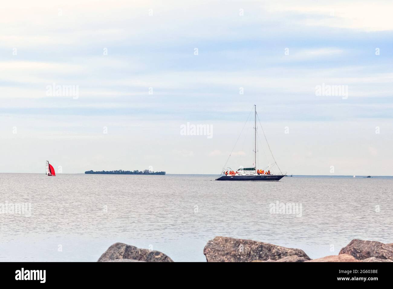 Pierres de granit dans l'eau sur la rive du golfe de Finlande. Les voiliers flottent sur l'eau. Banque D'Images