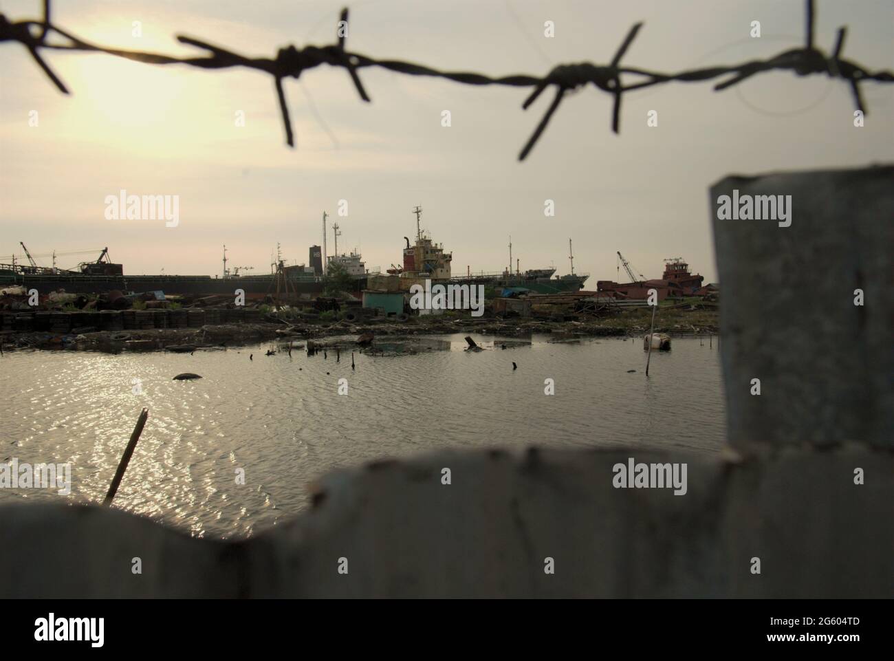 Une cour de démolition de navires est vue à travers une clôture près du village côtier de Marunda à Cilincing, Jakarta, Indonésie. Banque D'Images