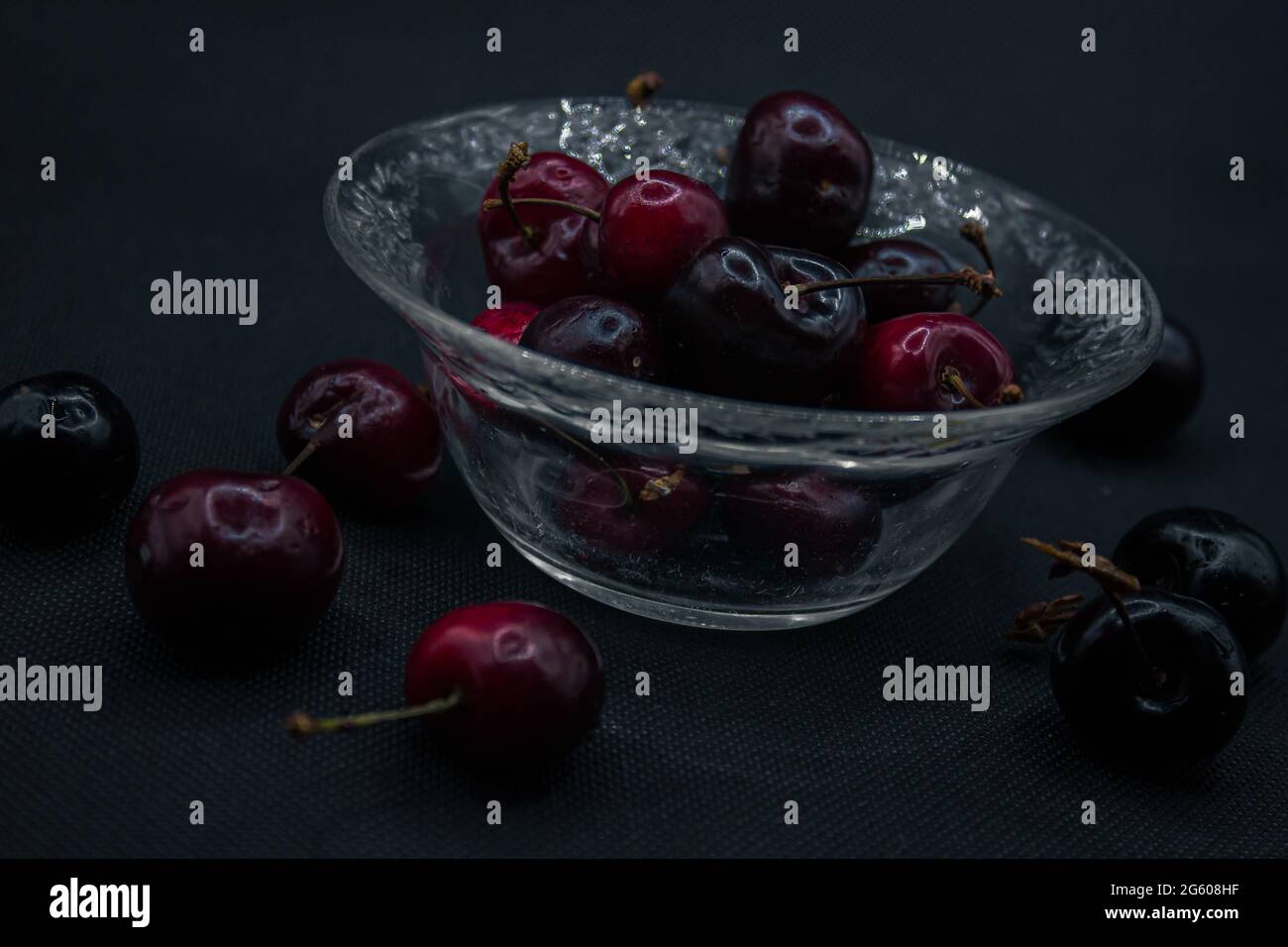 Cerises avec gouttes d'eau isolées dans le fond noir.Cerises mûres.Cerise rouge sucrée. Vue sur le dessus.Style rustique. Papier peint aux fruits Banque D'Images