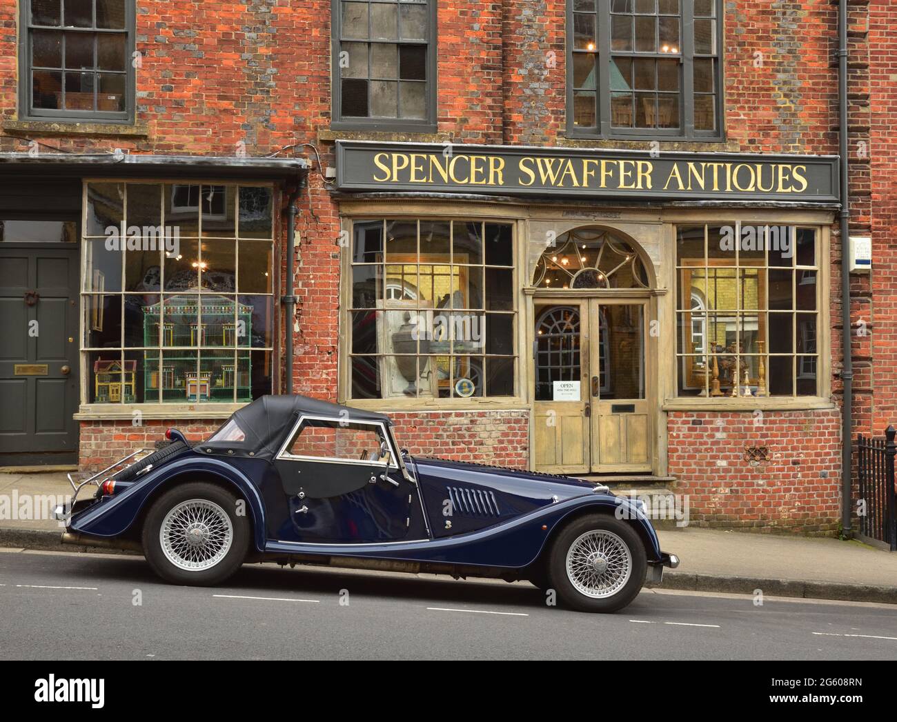 Voiture décapotable vintage ou rétro garée à l'extérieur d'un magasin d'antiquités à Arundel, West Sussex Banque D'Images