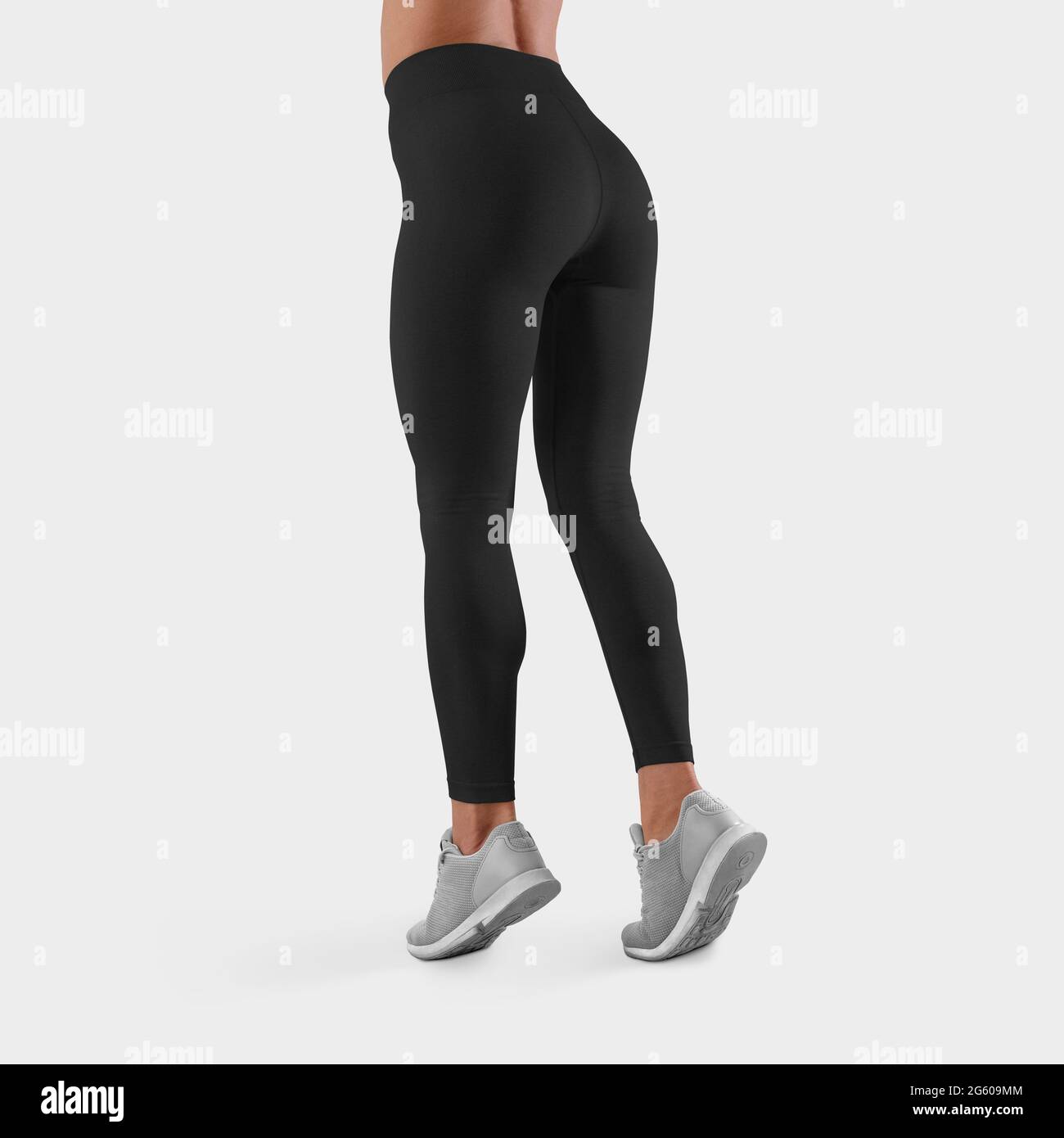 Modèle de leggings noirs pour le fitness et le sport sur une fille mince  debout sur les orteils sur un fond blanc dans le studio, vue arrière.  Pantalon maquette Tigh Photo Stock -