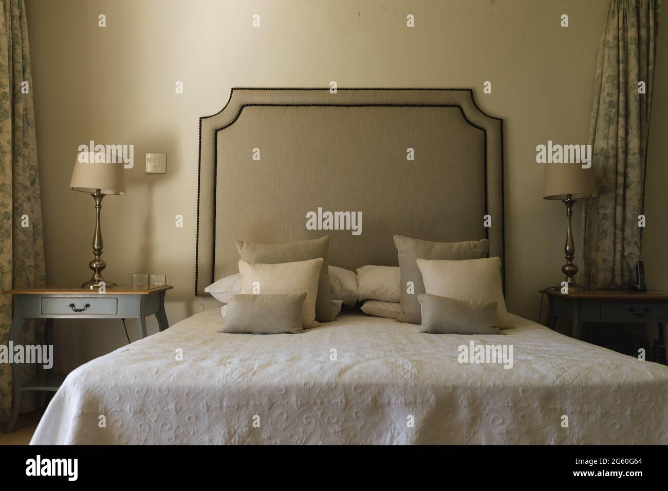 Vue générale de la chambre ensoleillée de luxe avec grand lit et tables de nuit Banque D'Images