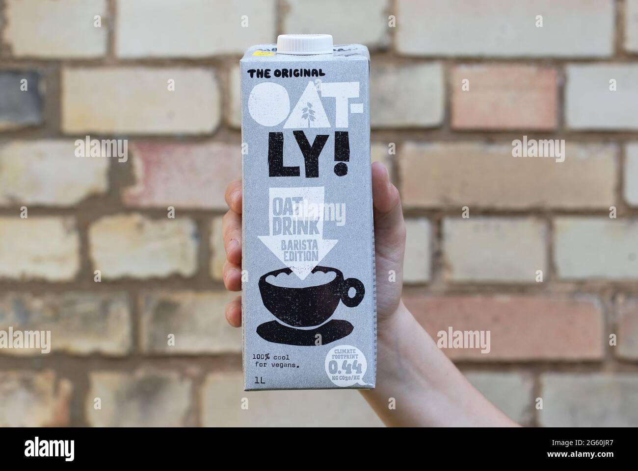 Londres / Royaume-Uni - 24 août 2019 - main tenant un carton de lait Oatly. Oatly est une alternative au lait végétalien sans lait. Banque D'Images