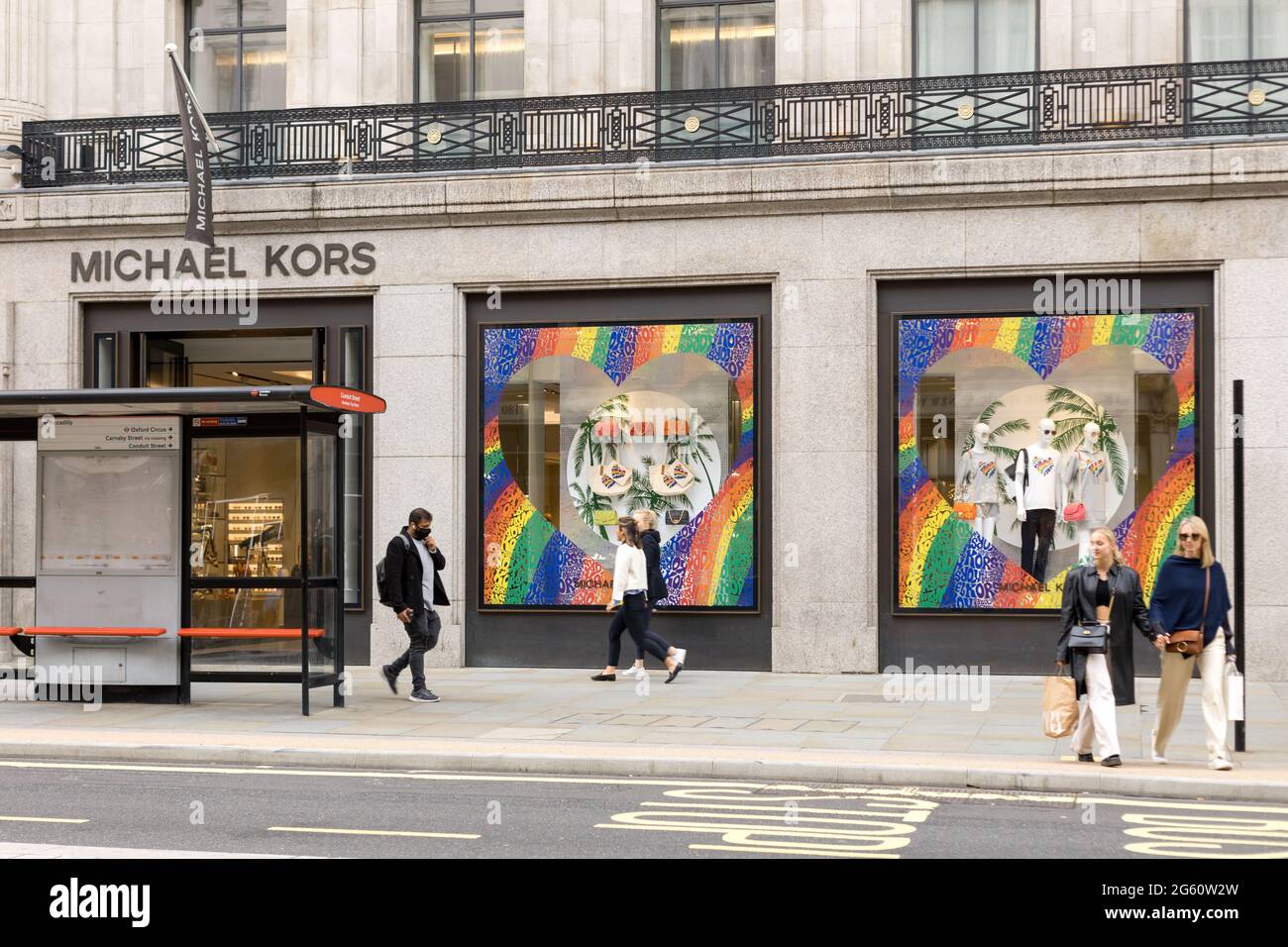 Londres, Royaume-Uni. 23 juin 2021. Les gens marchent devant un Michael Kors  décoré de couleurs arc-en-ciel sur ses fenêtres à l'Oxford Circus à Londres.June  est traditionnellement le mois de la fierté au