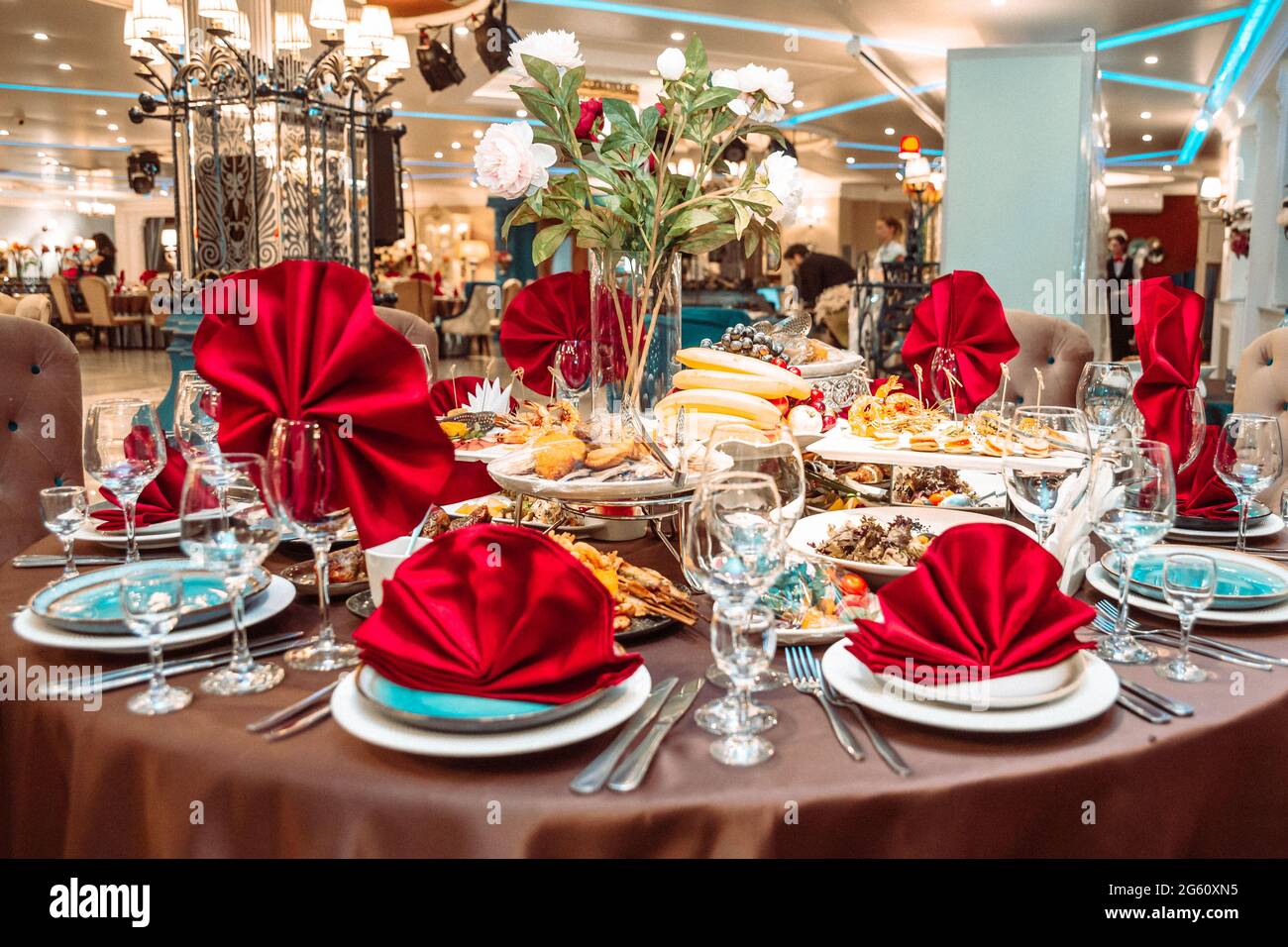 une table dans un restaurant avec de la nourriture et des serviettes rouges. Banque D'Images