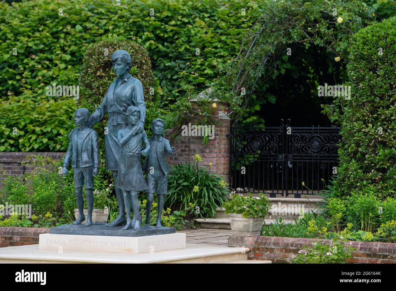 La statue de Diana, princesse de Galles, de l'artiste Ian Rank-Broadley, dans le jardin en contrebas de Kensington Palace, Londres. La statue de bronze dépeint la princesse entourée de trois enfants pour représenter l'universalité et l'impact générationnel de son travail. Ses cheveux courts, son style de robe et son portrait sont basés sur la dernière période de sa vie. Sous la statue se trouve une plinthe gravée de son nom et de la date du dévoilement, et devant se trouve une pierre pavée gravée d'un extrait inspiré de la mesure d'UN poème de l'Homme. Date de la photo : jeudi 1er juillet 2021. Banque D'Images