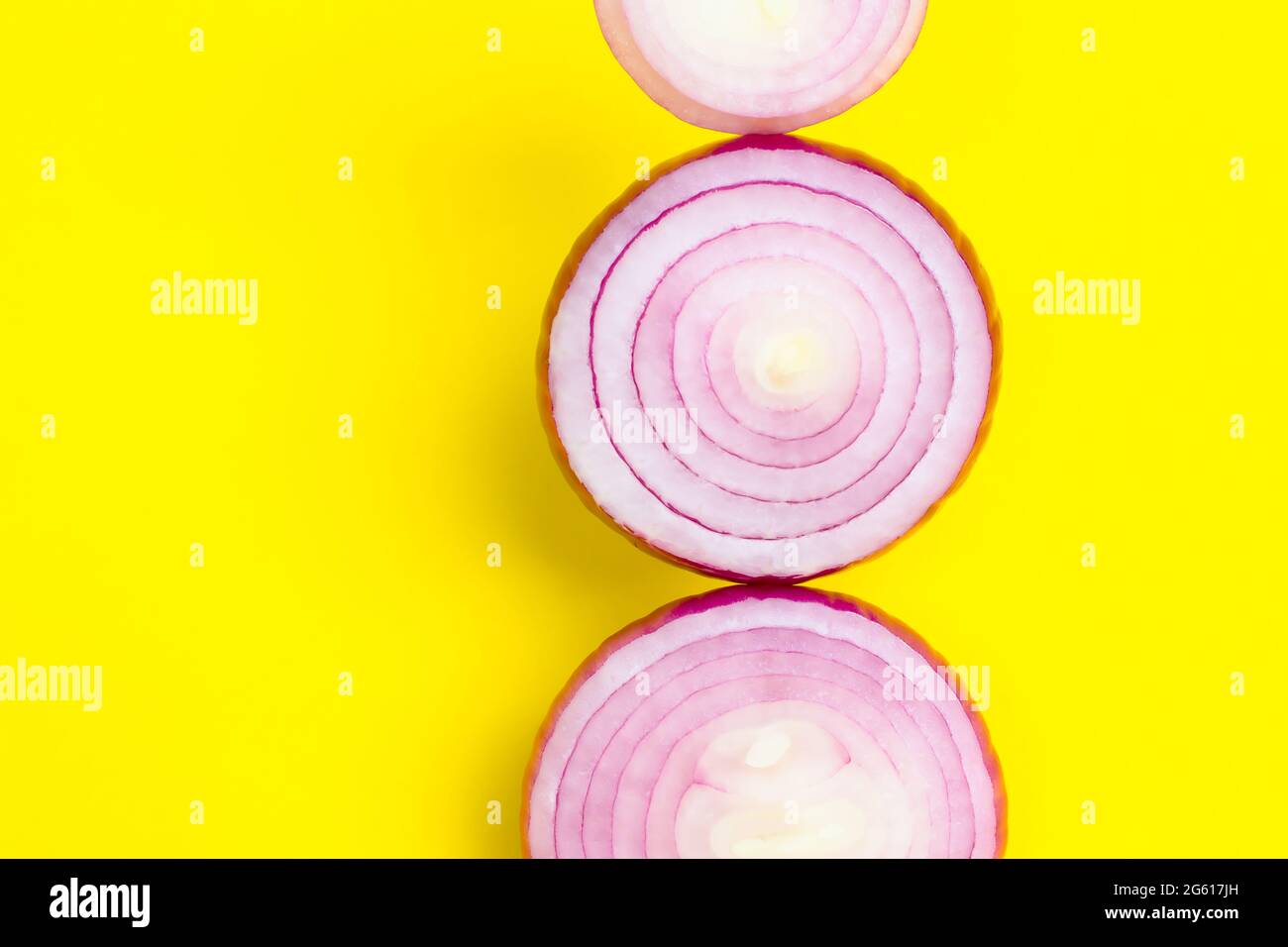 Émincé d'oignon violet sur fond jaune. Copier l'espace. Banque D'Images