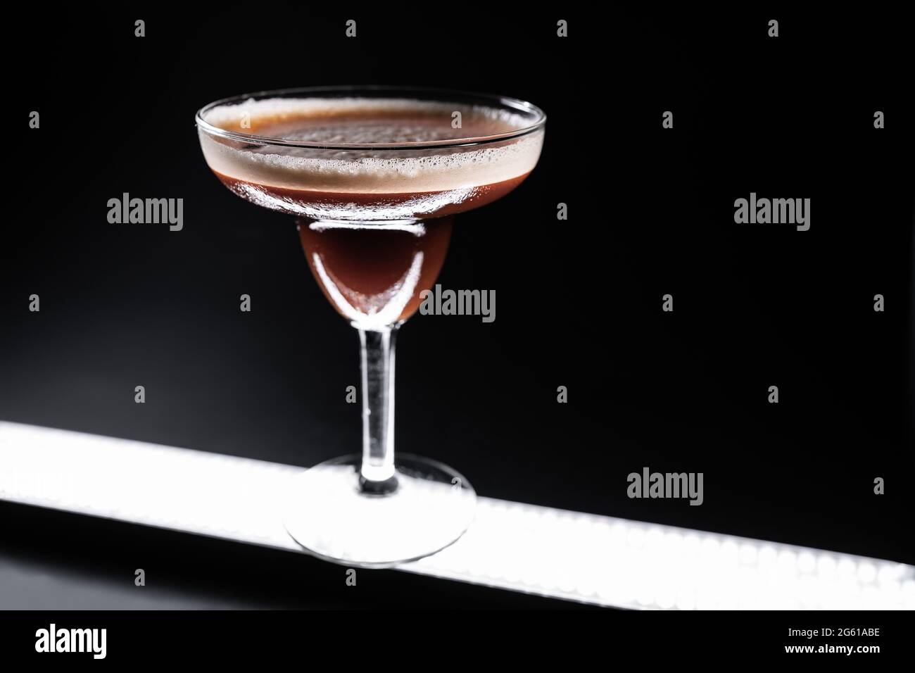 cocktail de luxe espresso martini dans un verre élégant sur fond noir Banque D'Images