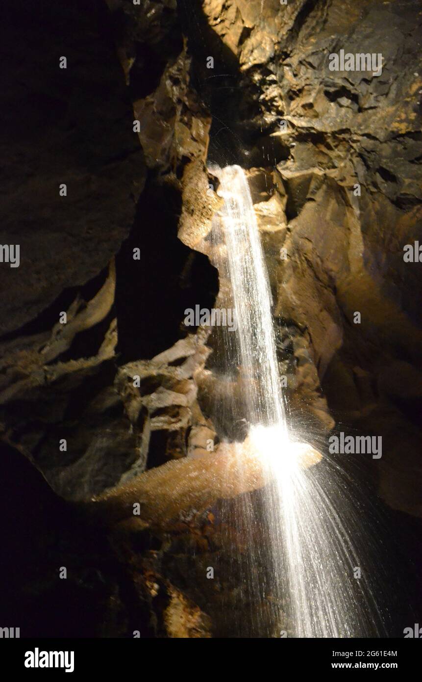 Cascade dans des grottes avec des éclaboussures d'eau en Irlande. Banque D'Images