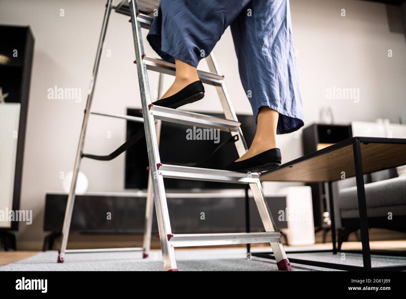 Sécurité de l'échelle. Femme grimpant escabeau dans des chaussures Banque D'Images