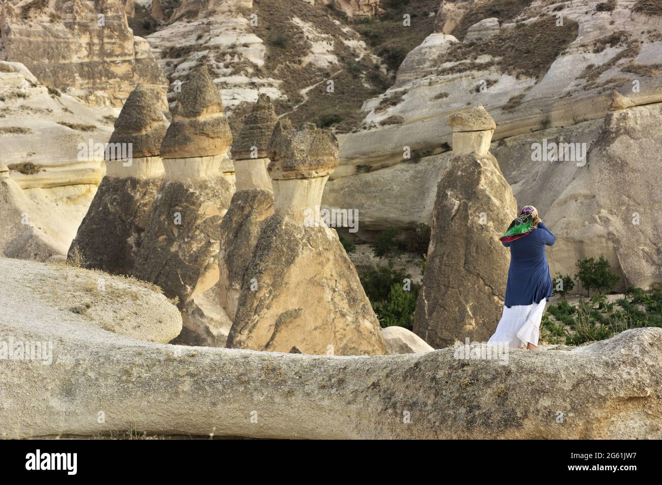 Un souvenir photo des cheminées de fées dans la vallée de Zelve point de repère du tourisme en Cappadoce femme musulmane prenant des photos d'une formation de roche en Turquie Banque D'Images