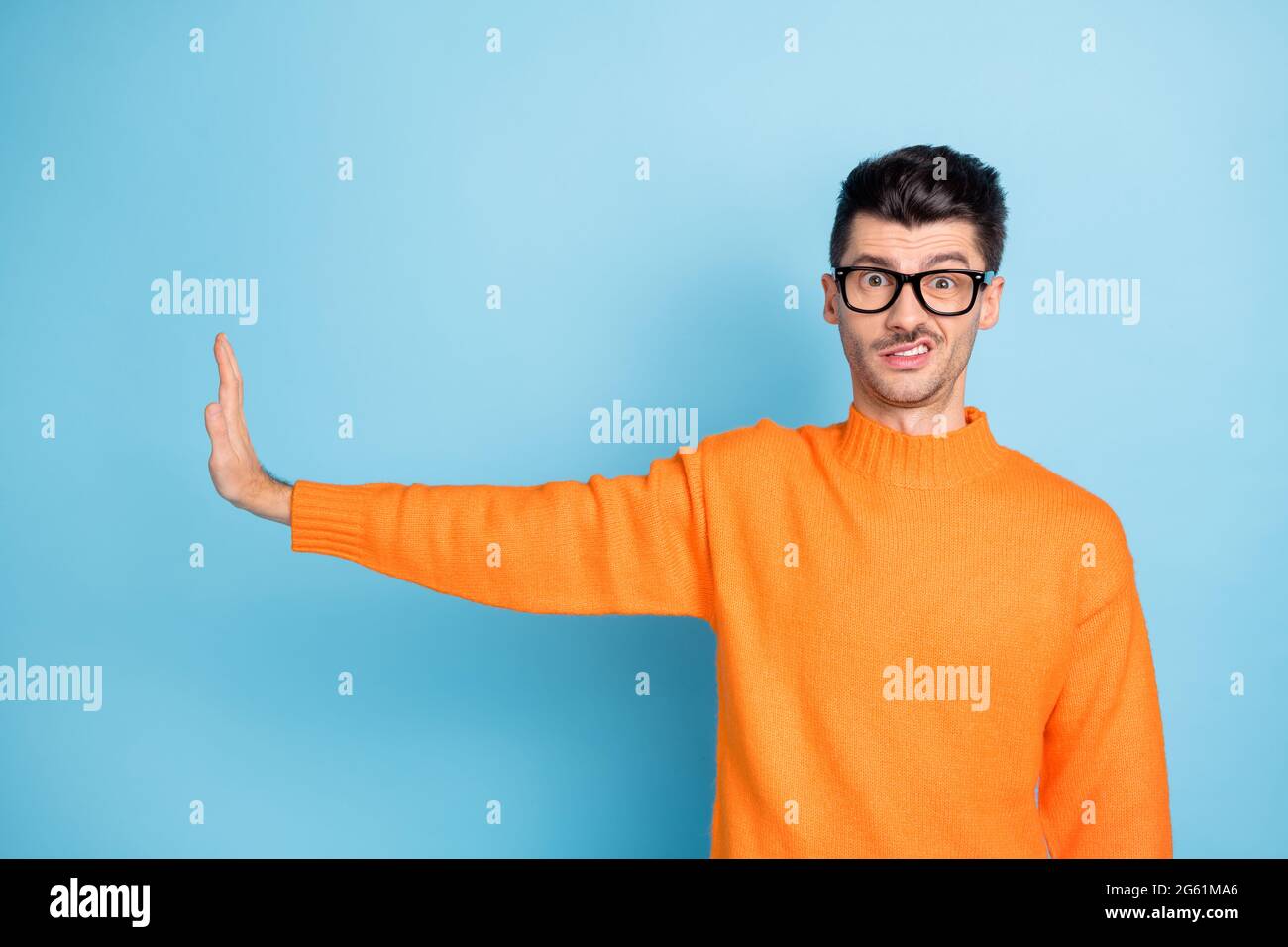 Photo des dents négatives de jeune gars montrent le rejet de paume de bras vide espace isolé sur fond bleu Banque D'Images
