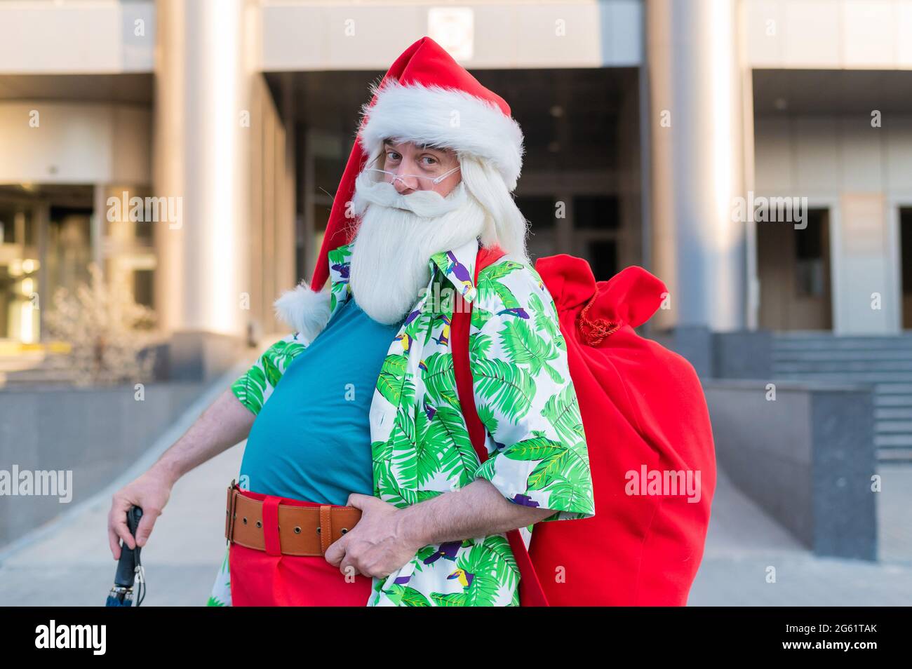 Le Père Noël vêtu de shorts parcourt la ville avec un parapluie Photo Stock  - Alamy
