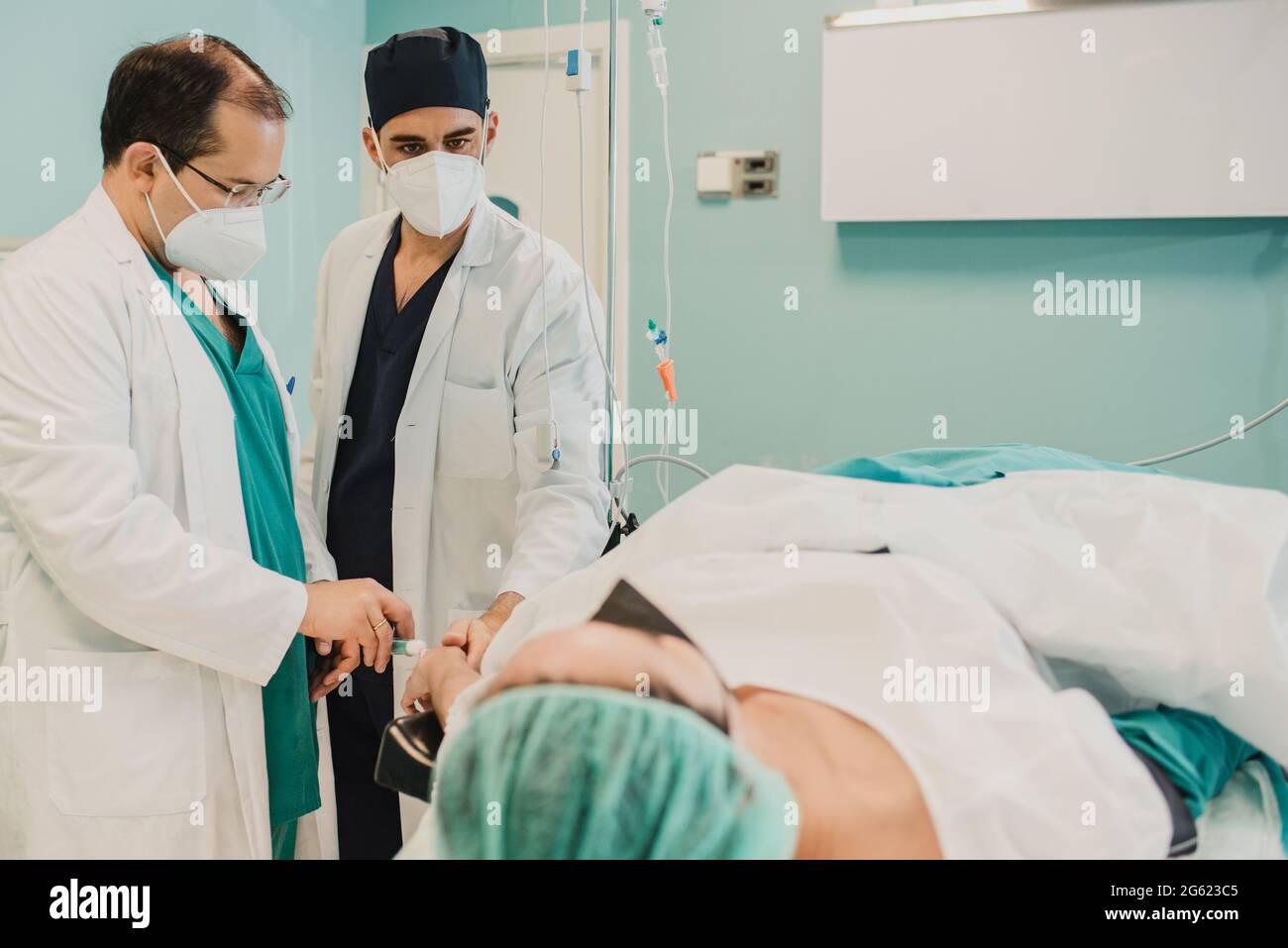 Médecin donnant l'anesthésie du patient avant l'opération chirurgicale à l'intérieur de l'hôpital moderne - Focus sur le visage droit du médecin Banque D'Images
