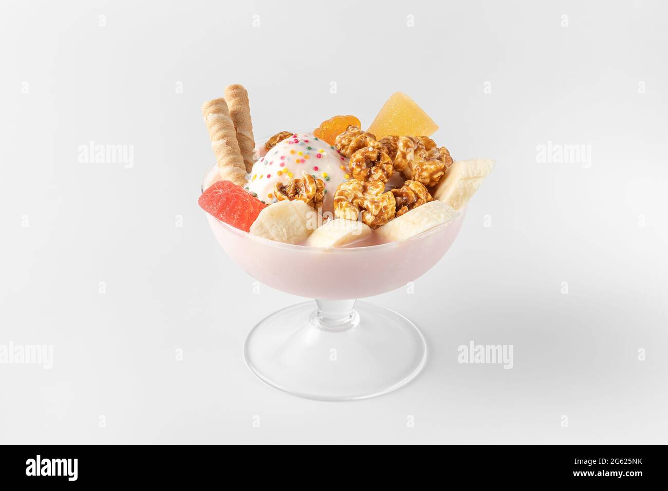 bol à crème glacée avec yaourt frais congelé, fruits, biscuits, banane, noix isolées sur un fond blanc et gris avec des ombres naturelles Banque D'Images