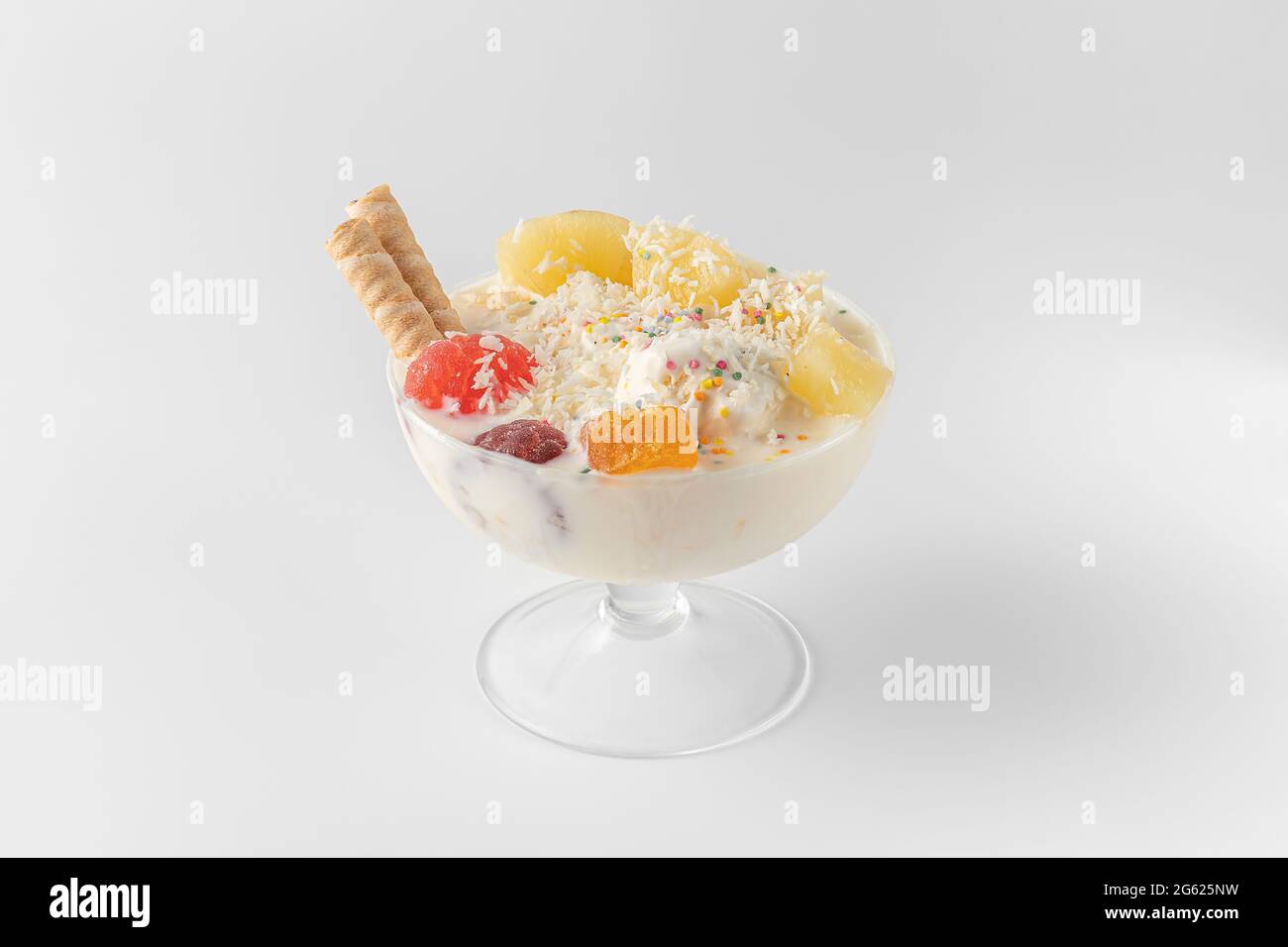 bol à crème glacée avec yaourt frais congelé, fruits, biscuits, ananas isolé sur un fond blanc et gris avec des ombres naturelles Banque D'Images