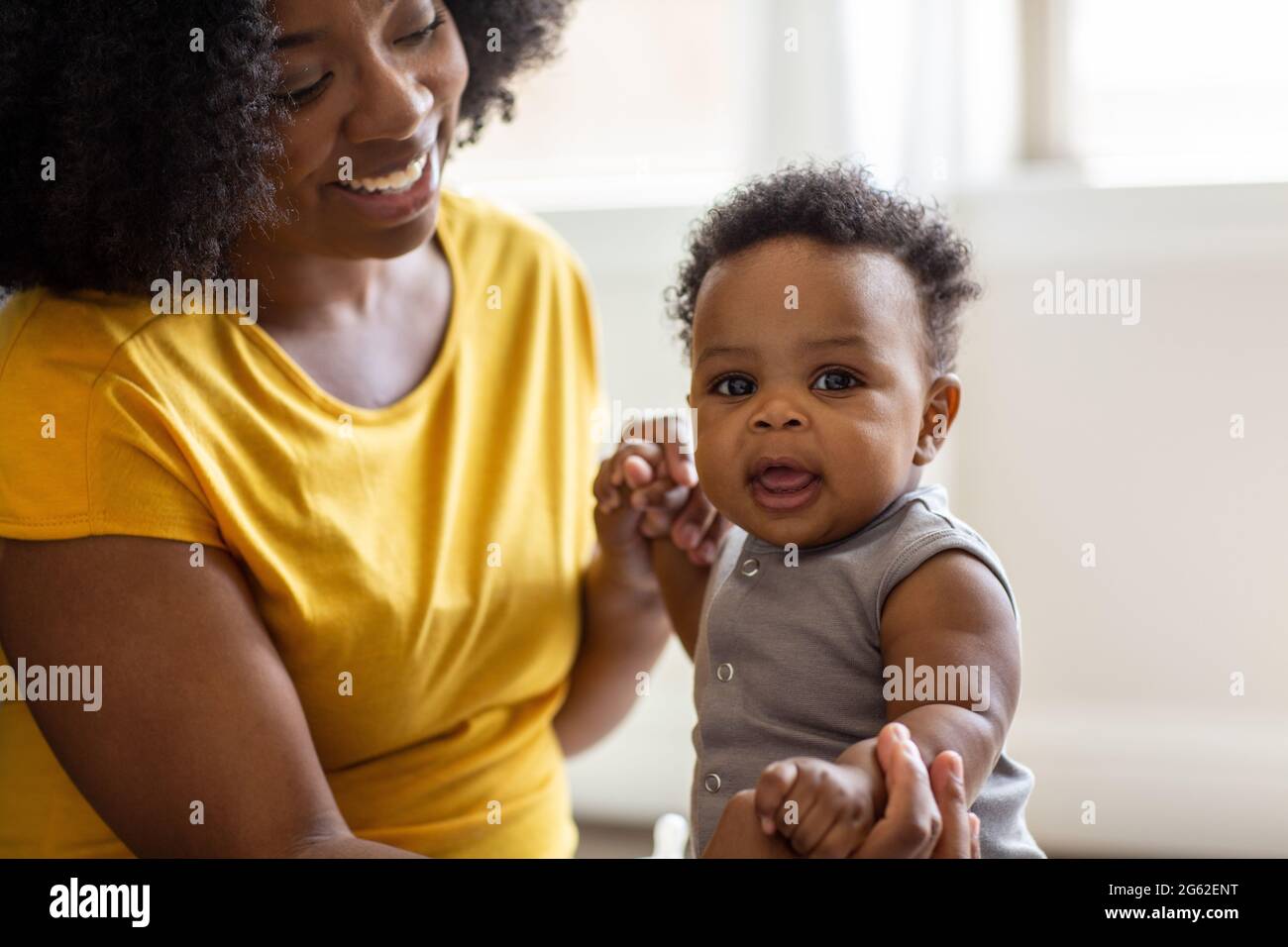 Une mère heureuse souriant et jouant avec son fils à la maison. Banque D'Images