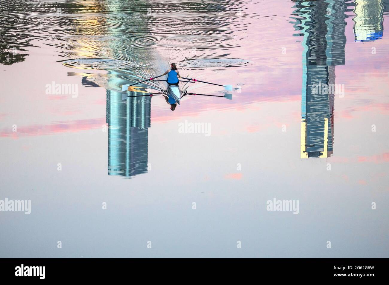 Melbourne Australie réflexions sur les gratte-ciel. Les bâtiments de Melbourne City se reflètent sur la Yarra River tandis qu'un rameur traverse la surface. Banque D'Images