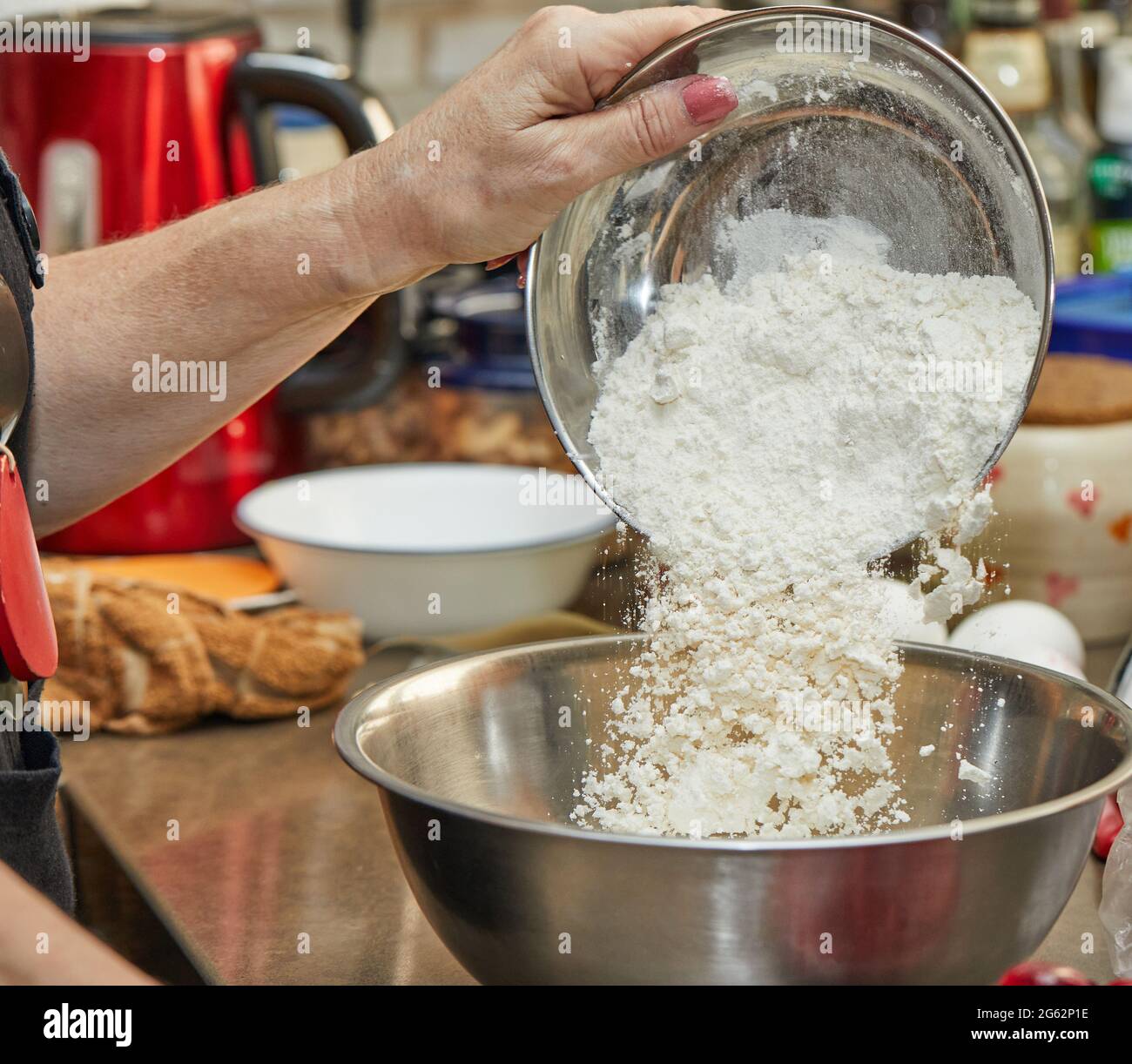 Le chef verse de la farine dans un bol pour préparer une tarte aux cerises, une clafoutis. Recette étape par étape Banque D'Images