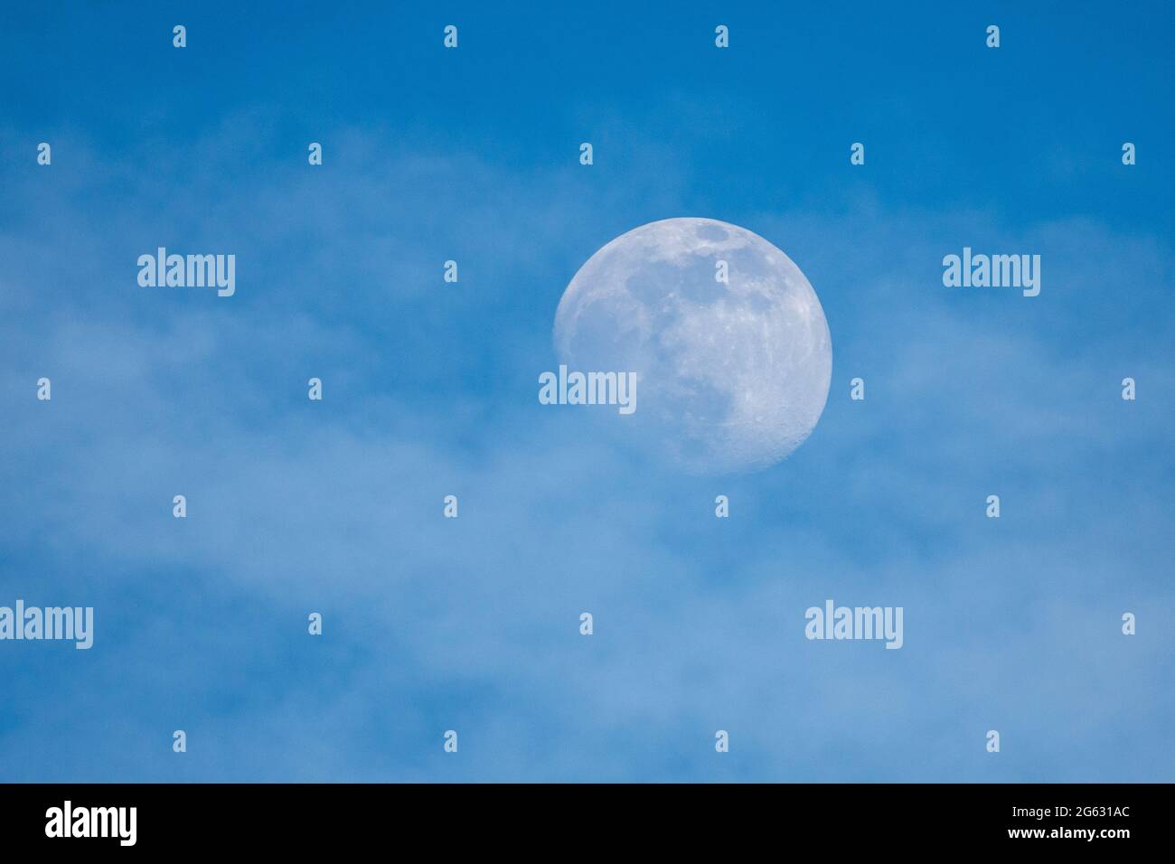 presque pleine lune sur ciel bleu Banque D'Images