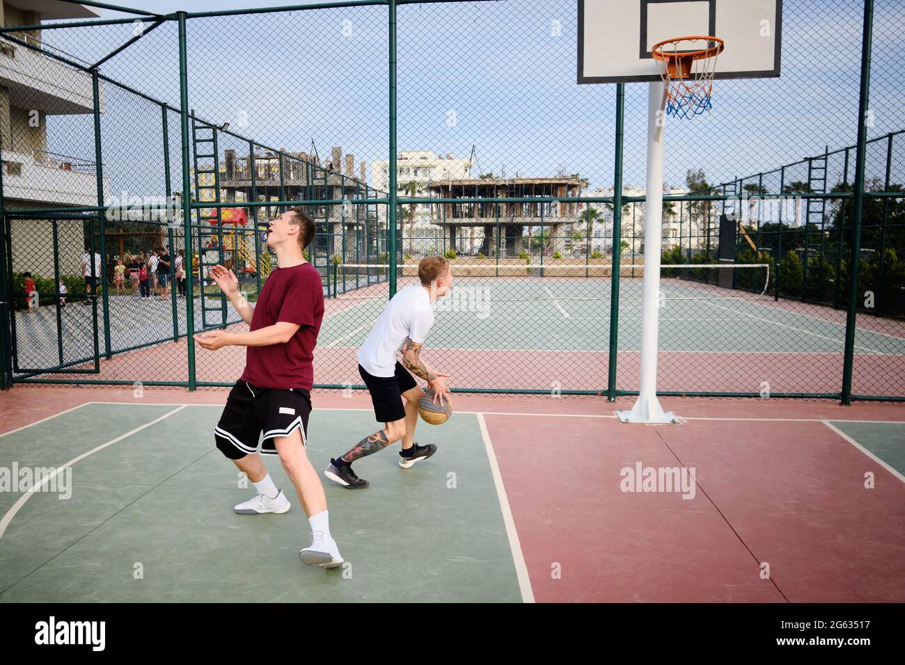 Deux hommes jouent au basket-ball sur le terrain extérieur Banque D'Images
