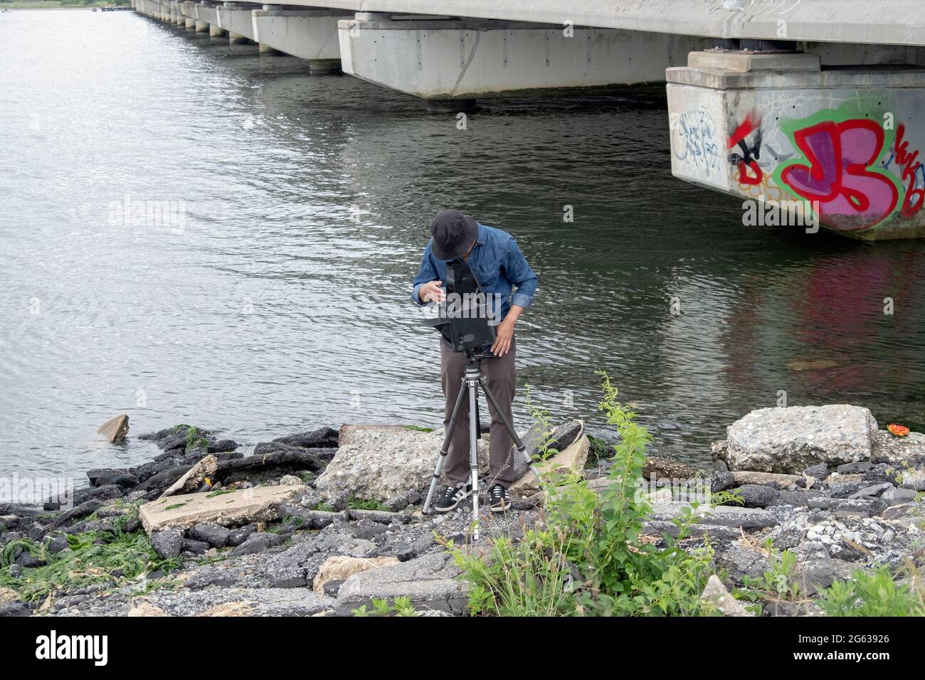 Un photographe de paysage d'ancienne école utilisant un appareil photo grand format Graflex prend des photos à Jamaica Bay à Queens, New York City. Banque D'Images