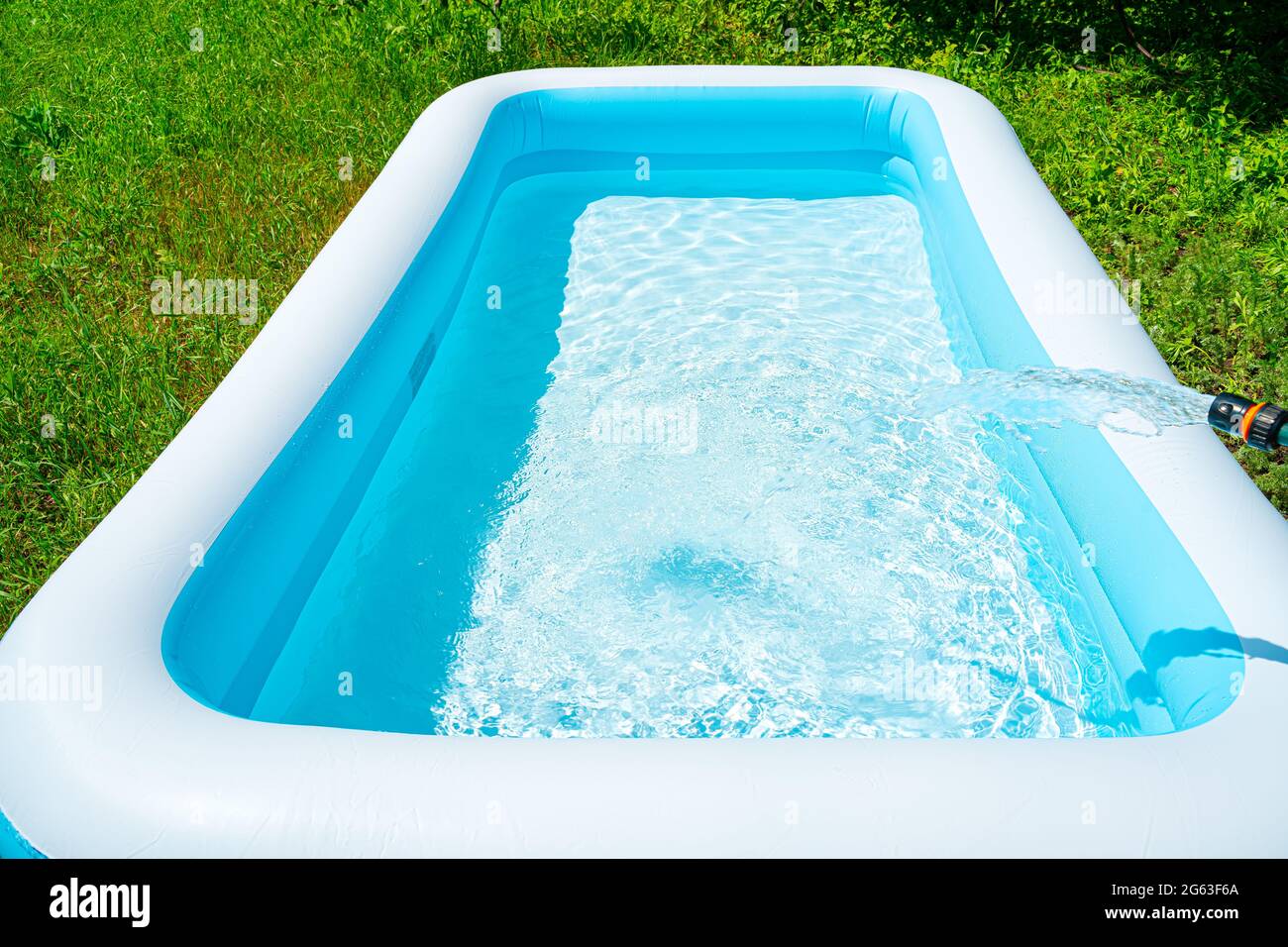 Entretien de la piscine, remplissage de la piscine avec de l'eau propre. Divertissement d'été. Vue latérale, espace pour la copie. Banque D'Images