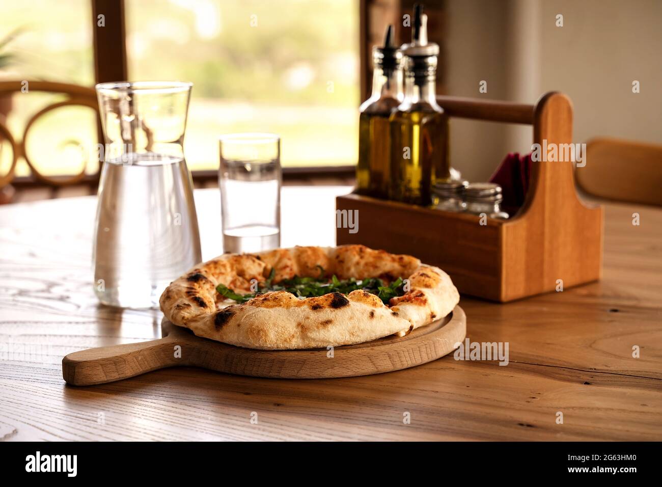 Pizza et eau dans une verseuse en verre sur une table en bois de style vintage. Restaurant italien de fond pour votre conception. Concept de style de vie du restaurant. Conce alimentaire Banque D'Images