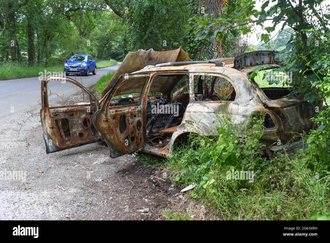 Une voiture brûlée se déversait sur une zone de départ en bordure de route dans une route de campagne. Photo prise Ryedown Lane près de Romsey Hampshire Angleterre. Banque D'Images