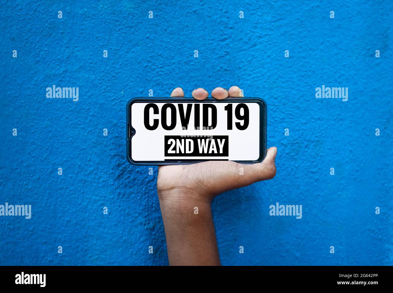 Covid 19 texte de 2e voie sur l'écran de smartphone isoler sur fond bleu avec espace de copie pour le texte. Banque D'Images