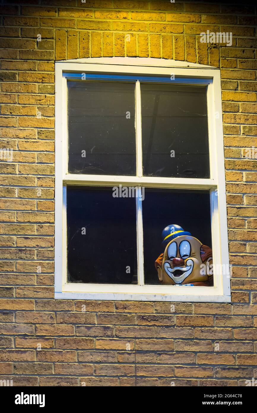 Clowns tête à la fenêtre regardant dehors Banque D'Images