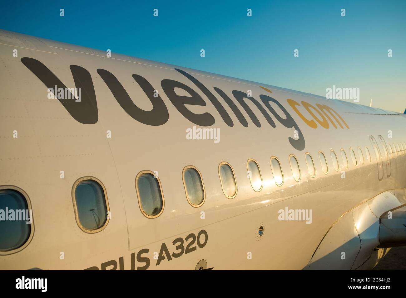 Un avion appartenant à la compagnie aérienne Vueling est vu sur le tarmac de l'aéroport El Prat à Barcelone, Espagne, le 25 juin 2021, au lever du soleil avec une lumière chaude. Banque D'Images