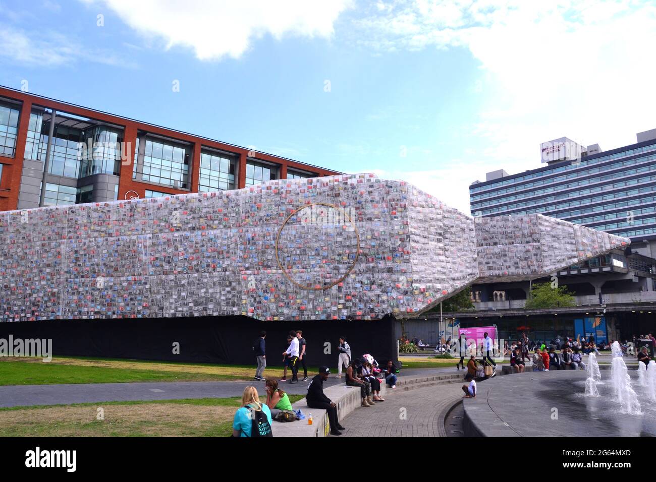 Partie du Festival international de Manchester à Manchester, Angleterre, Royaume-Uni, du 1er au 18 juillet 2021, une nouvelle œuvre d'art monumentale: Une réplique colossale de 42m de Big Ben : intitulée "BIG BEN COUCHÉ AVEC DES LIVRES POLITIQUES". Couché presque horizontal et couvert par 20,000 copies de livres qui ont façonné la politique britannique, ce point de repère temporaire inspirera de nouvelles conversations sur ce que nous apprécions. Les clients peuvent réserver un billet gratuit pour explorer l'intérieur (de 10:00 à 21:30 tous les jours), où vous pourrez découvrir un film et une bande originale créés par l'artiste Marta Minujín. Banque D'Images