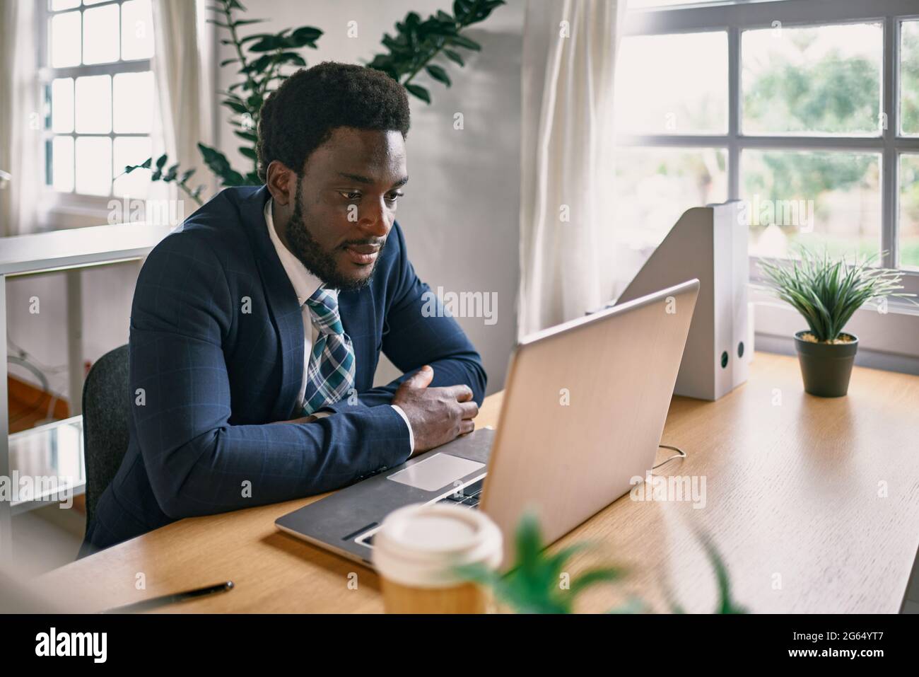 Jeune homme noir travaillant dans un bureau moderne - Focus sur le visage Banque D'Images